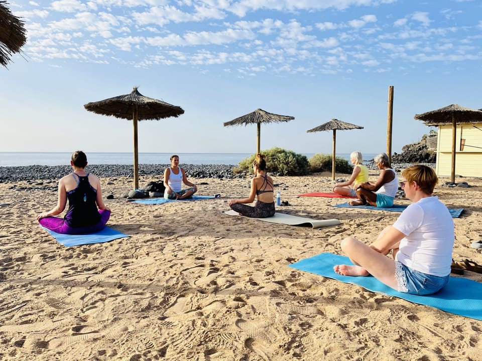 Yoga met de groep op het strand